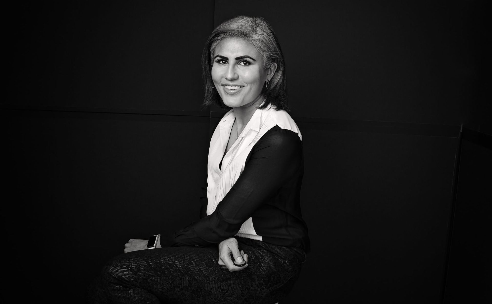 Black-and-white portrait of Rashmi Gill seated in her New York studio